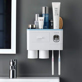 Wall-mounted white plastic bathroom organizer with cups, toothbrushes, and skincare bottles