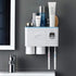 Wall-mounted white plastic bathroom organizer with cups, toothbrushes, and skincare bottles