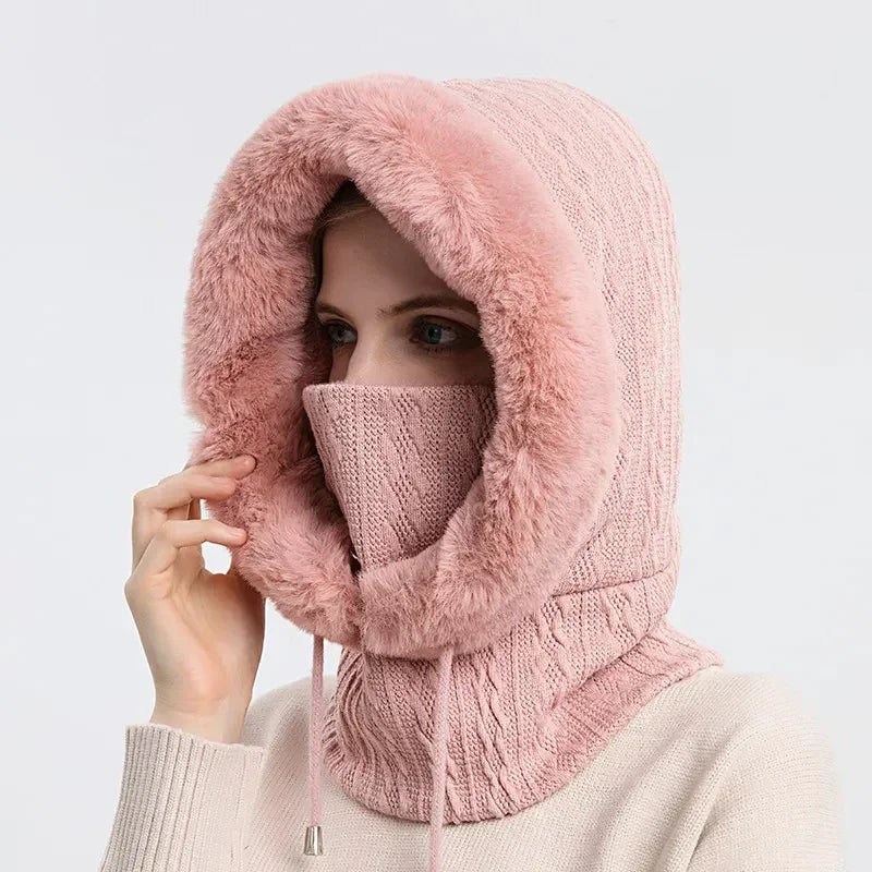 Woman wearing a pink knit hood with faux fur trim, face cover, and drawstring for winter
