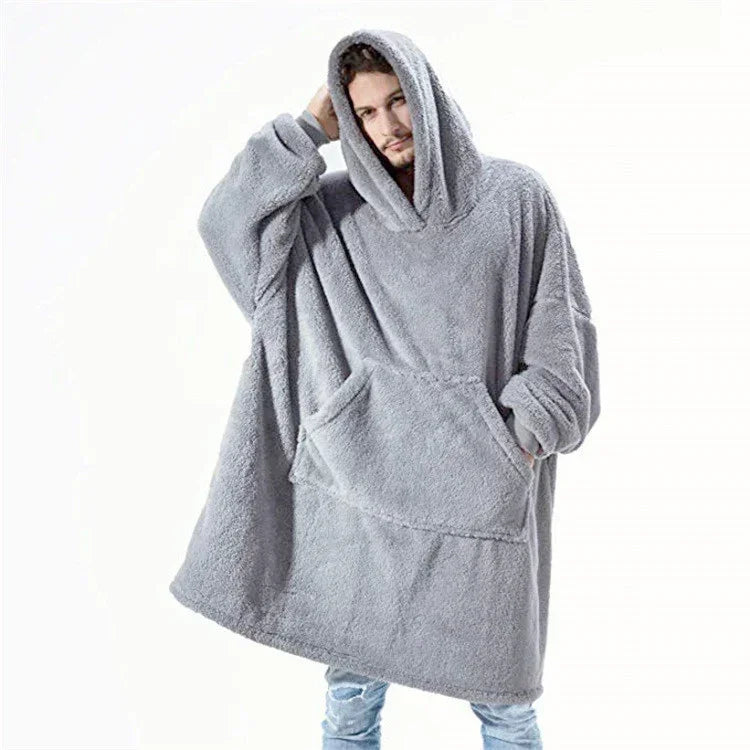 Man wearing oversized grey fleece hoodie with large front pocket and relaxed fit.