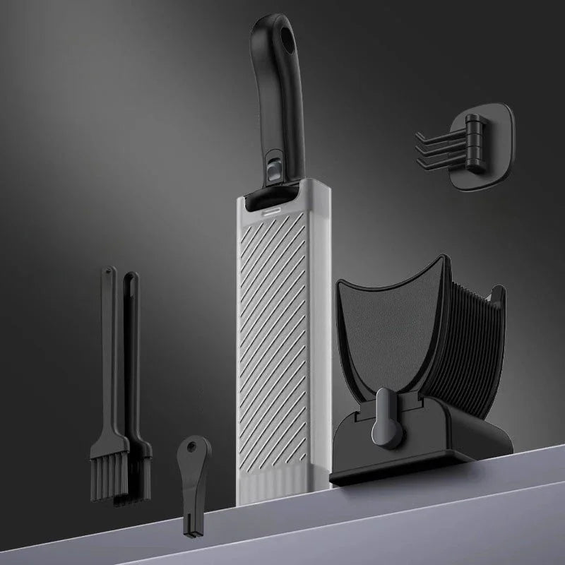 Modern kitchen utensil set with black and silver slicer, brushes, and holder on gray background