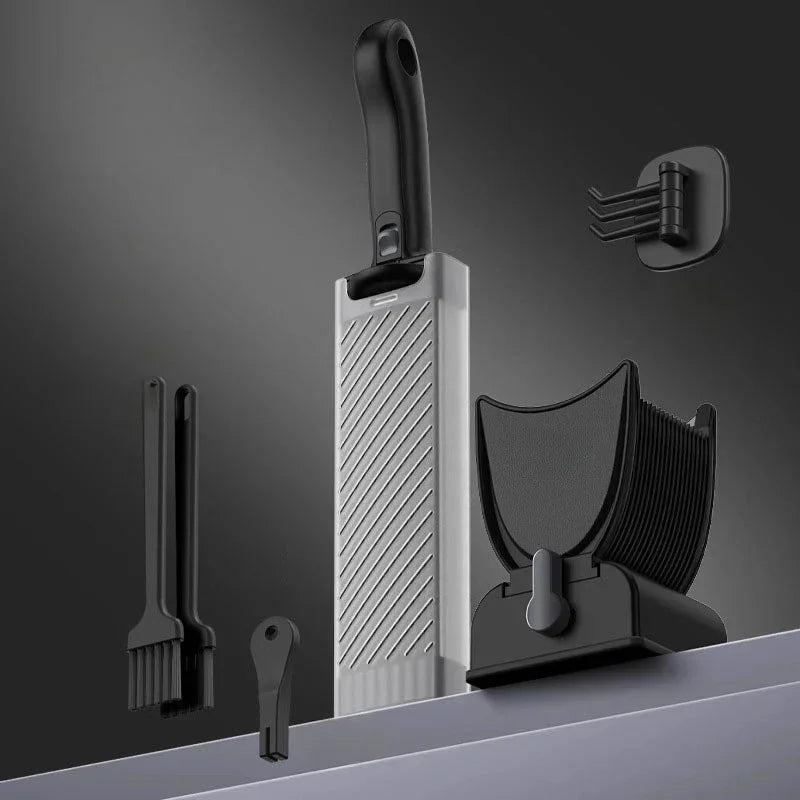 Modern kitchen utensil set with black and silver slicer, brushes, and holder on gray background