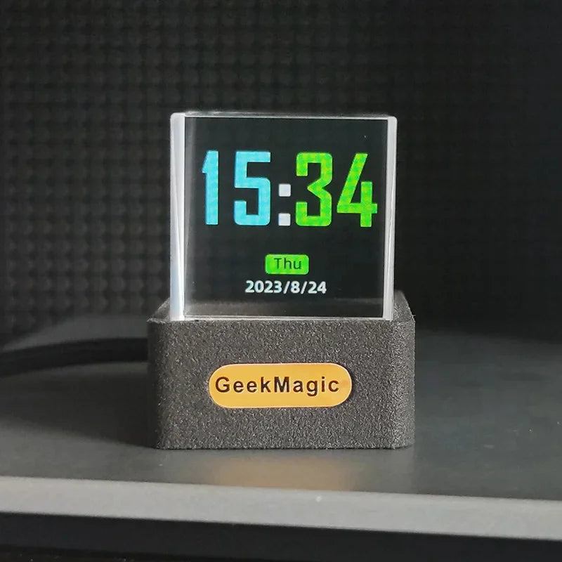 Modern transparent digital clock with colorful LED display and black rectangular base