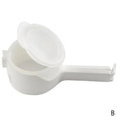 White plastic handheld kitchen tool with handle, open lid, and round compartment