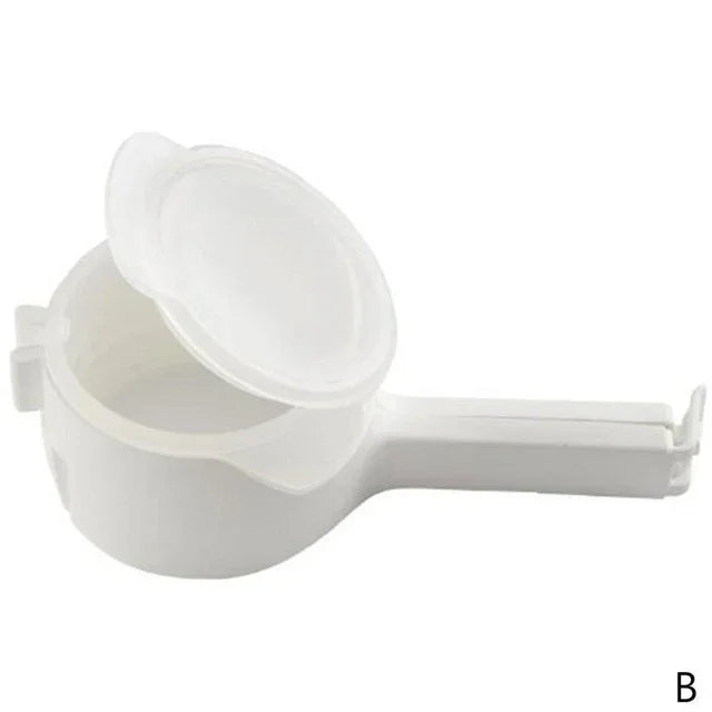 White plastic handheld kitchen tool with handle, open lid, and round compartment