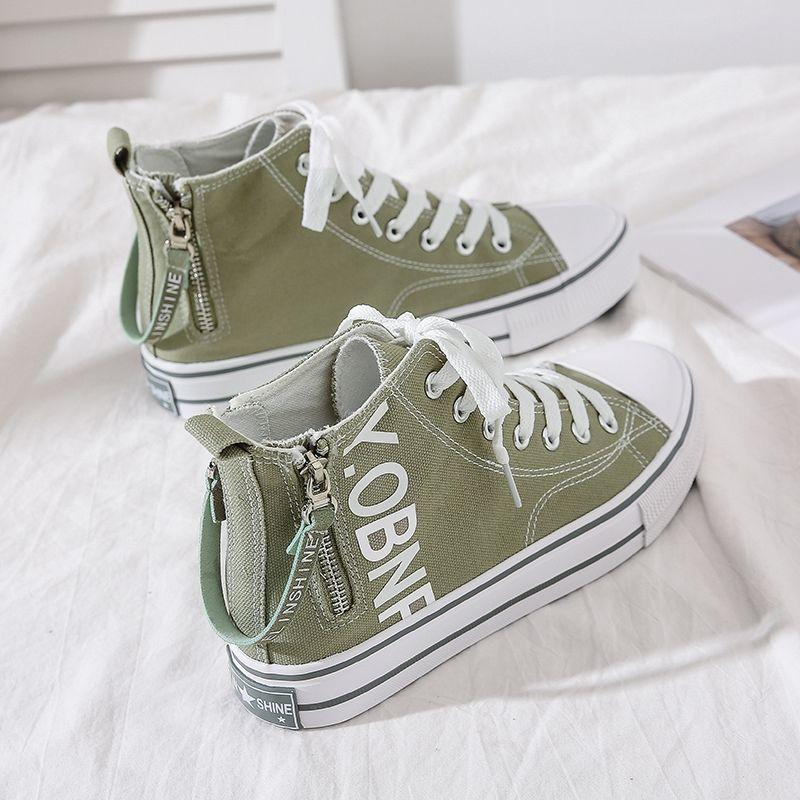 Sage green canvas high-top sneakers with white laces, printed lettering, side zipper, and chunky sole