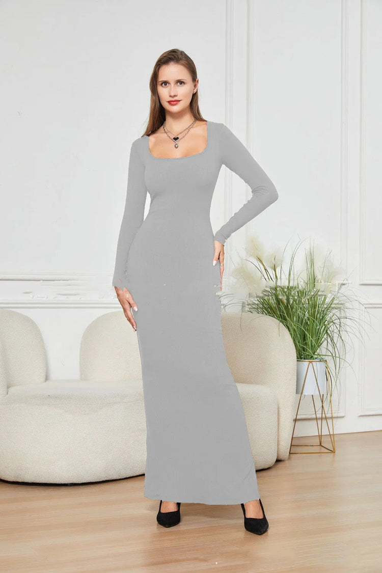 Woman wearing a fitted light gray long sleeve maxi dress with square neckline