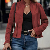 Woman wearing a fitted maroon suede jacket, black top, and high-waisted blue jeans.