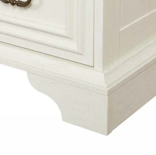 Close-up of off-white wooden furniture base with carved molding and vintage handle
