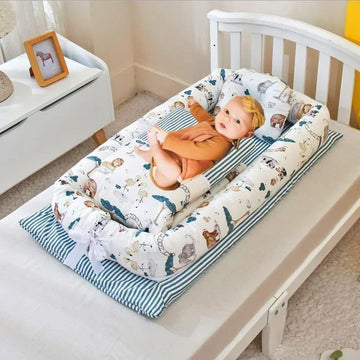Baby in brown long sleeve romper with headband, lying in soft animal print cotton baby nest on striped pad