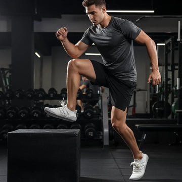 Man in athletic fit, moisture-wicking dark gray t-shirt and black shorts training in gym