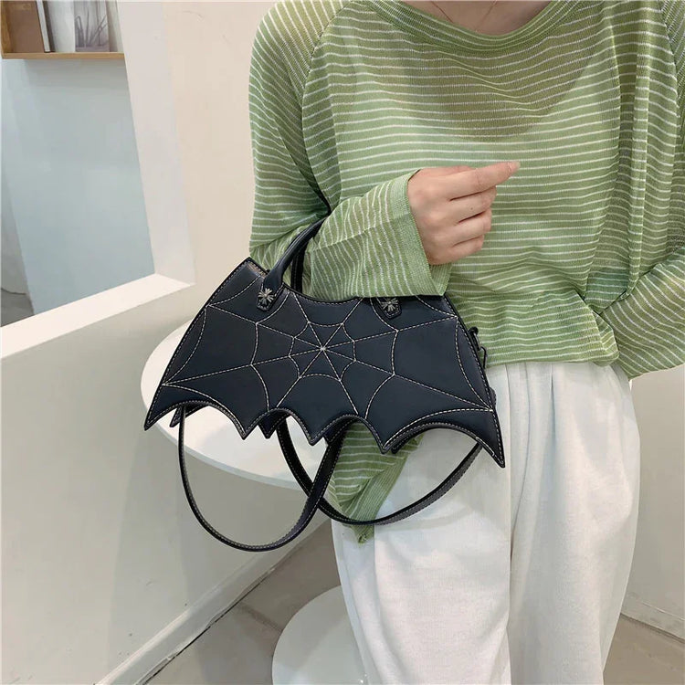 Loose green striped long sleeve top with relaxed fit, white pants, and bat-shaped black handbag
