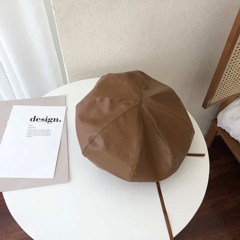 Brown faux leather beret hat with a smooth finish, classic round shape, and relaxed fit