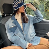 Woman in oversized light blue denim jacket, beige turtleneck sweater, and knit bucket hat