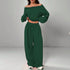 Woman wearing dark green off shoulder long sleeve top and matching wide-leg pants set