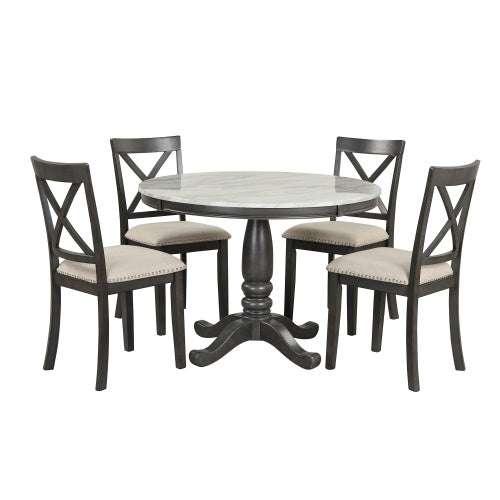 Round wood dining table with pedestal base and four matching cushioned chairs