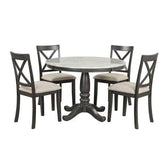 Round wood dining table with pedestal base and four matching cushioned chairs