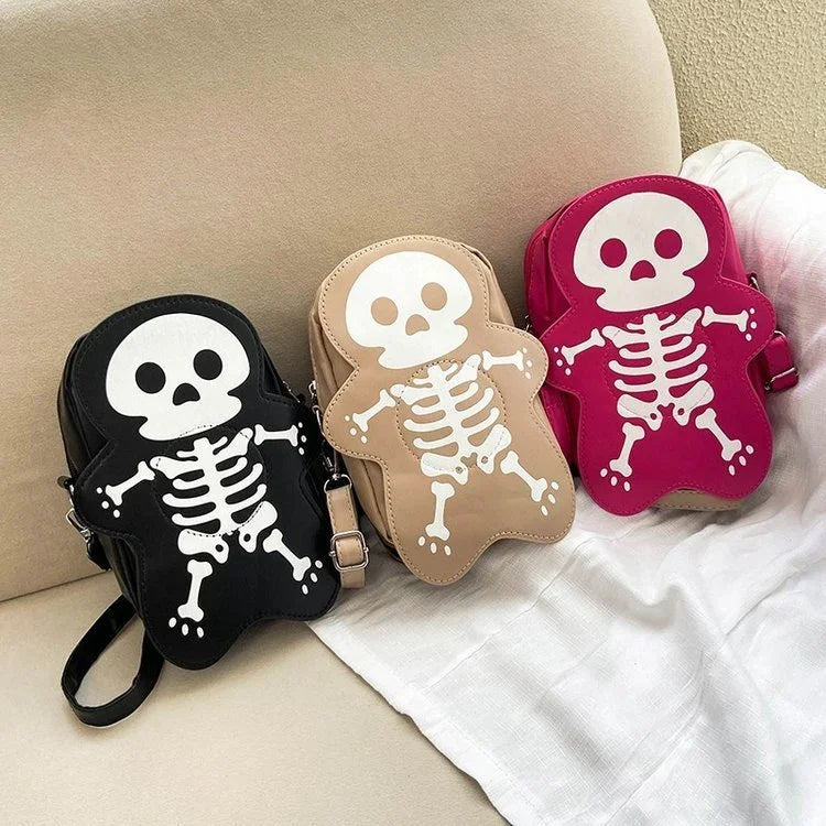 Three crossbody bags shaped like cartoon skeletons in black, beige, and pink faux leather
