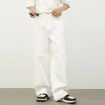 Loose fit white denim jeans with wide legs, styled with black and white sneakers.