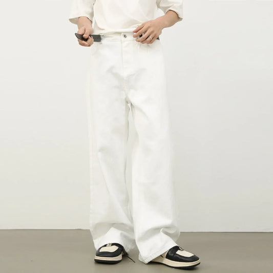 Loose fit white denim jeans with wide legs, styled with black and white sneakers.