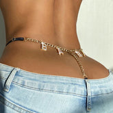 Gold chain waist belt with letter charms, paired with light blue low-rise denim jeans