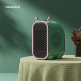 Green and pink modern mini heater with mesh grille on table, rounded edges, minimalist design