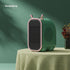 Green and pink modern mini heater with mesh grille on table, rounded edges, minimalist design