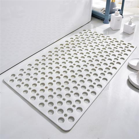 White non-slip bathroom mat with circular holes on tile floor, modern minimalist design