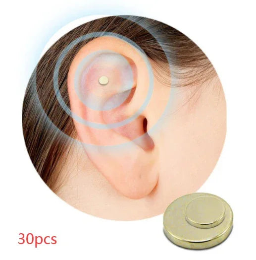 Gold ear acupressure magnet on ear, circular design, set of 30 pieces shown