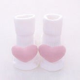 White ribbed baby socks with soft pink heart accents on toes, cozy cotton material, cute design.