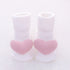 White ribbed baby socks with soft pink heart accents on toes, cozy cotton material, cute design.