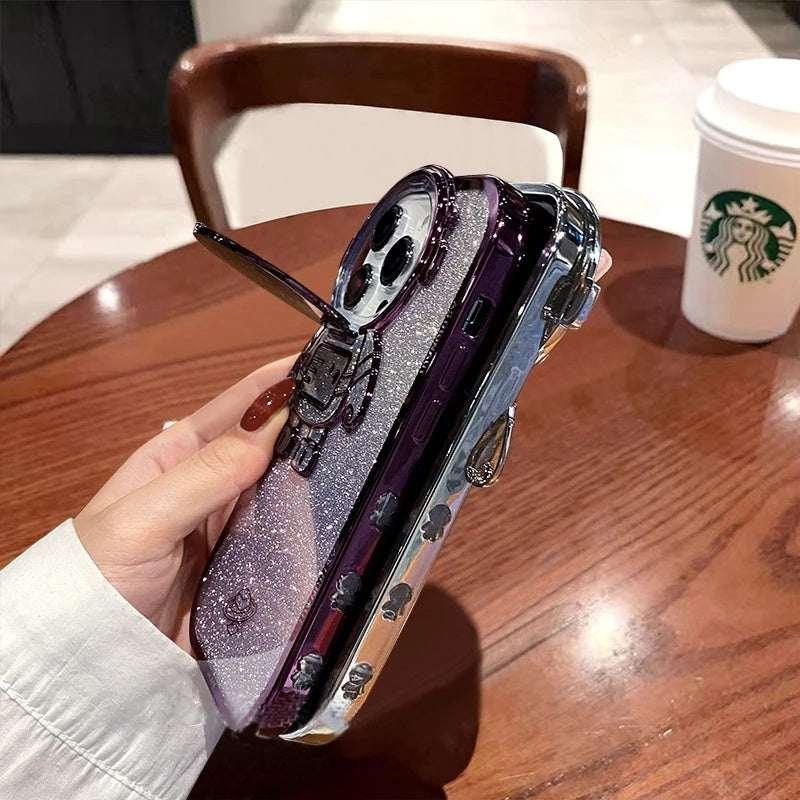 Hand holding a glittery silver and purple hard-shell phone case with metallic accents