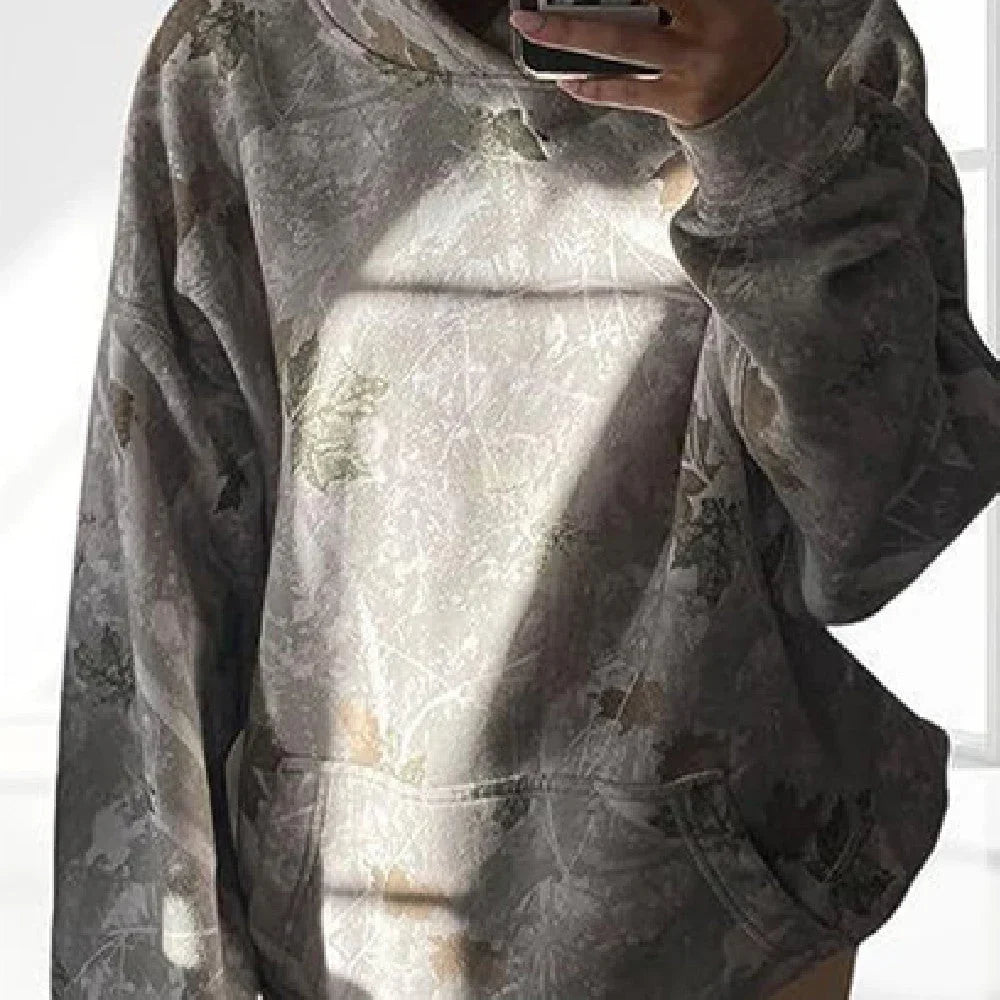 Oversized camouflage hoodie with front pocket, relaxed fit, and subtle earthy tones