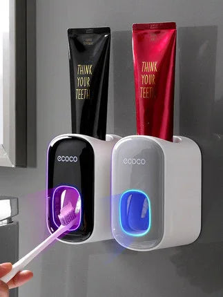 Wall-mounted automatic toothpaste dispensers in black and white with LED light, modern design