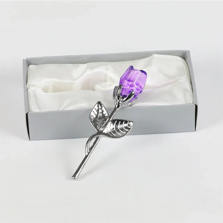 Silver metal rose with purple crystal flower in gift box on white satin