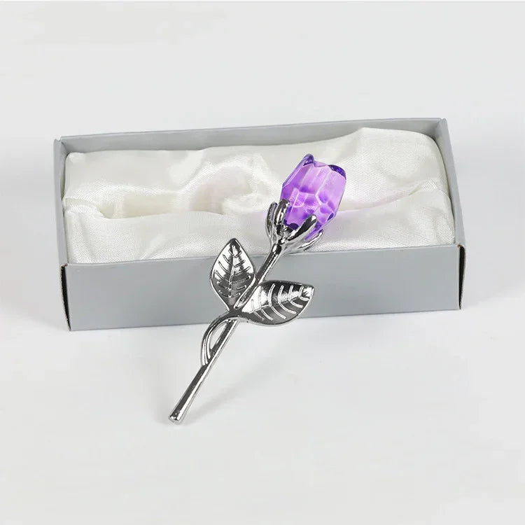 Silver metal rose with purple crystal flower in gift box on white satin