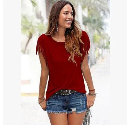 Woman in a casual red fringe sleeve top with denim shorts, relaxed fit, outdoor setting