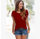 Woman in a casual red fringe sleeve top with denim shorts, relaxed fit, outdoor setting