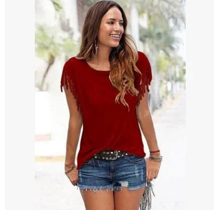 Woman in a casual red fringe sleeve top with denim shorts, relaxed fit, outdoor setting