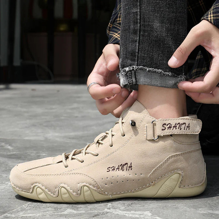 Beige suede high-top sneakers with lace-up front, chunky sole, and relaxed streetwear fit.