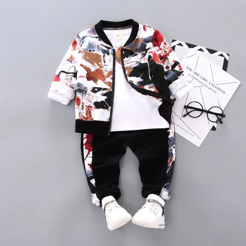 Trendy kids' streetwear set with abstract print bomber jacket, black joggers, and white sneakers