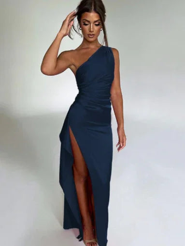 Woman wearing a navy blue one-shoulder evening gown with a thigh-high slit and fitted silhouette