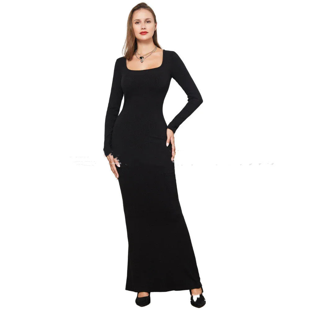 Woman wearing a fitted black long-sleeve maxi dress with square neckline.