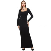 Woman wearing a fitted black long-sleeve maxi dress with square neckline.