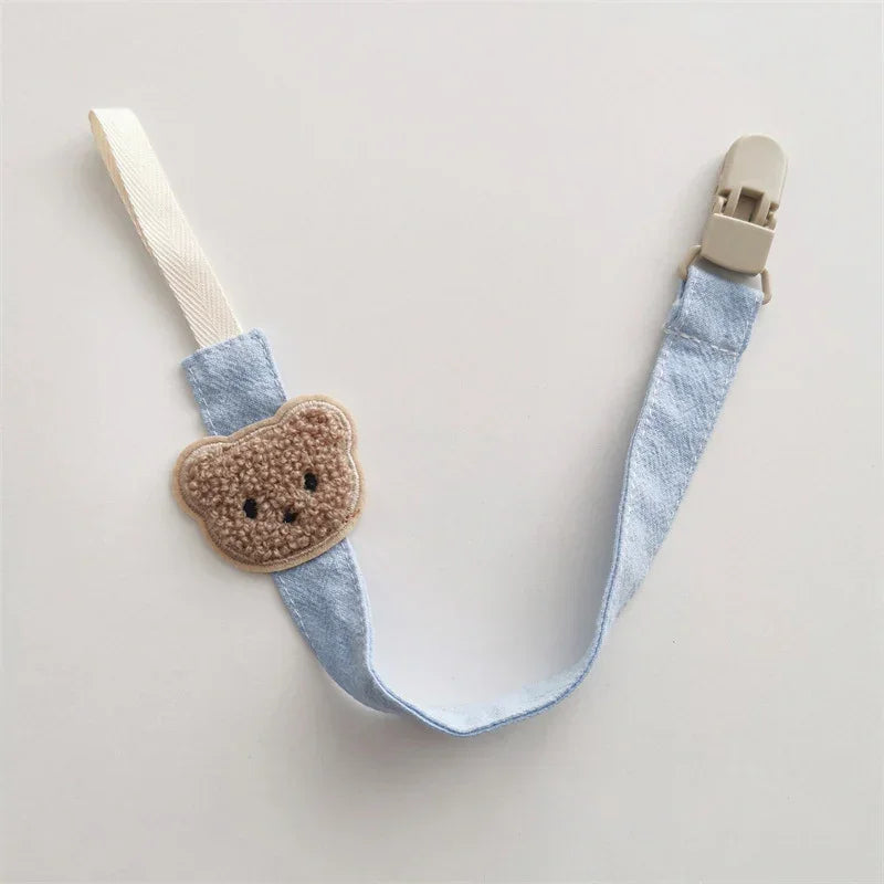 Light blue fabric strap with beige teddy bear patch and plastic clip, cute accessory