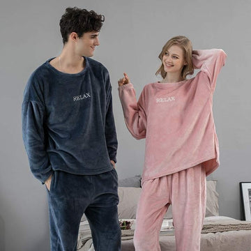 Couple in oversized plush loungewear sets, one navy blue and one blush pink, with relaxed fit.