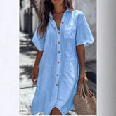 Woman in light blue linen button-up shirt dress with short sleeves and relaxed fit
