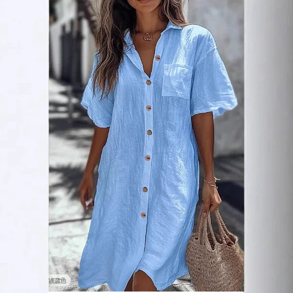 Woman in light blue linen button-up shirt dress with short sleeves and relaxed fit