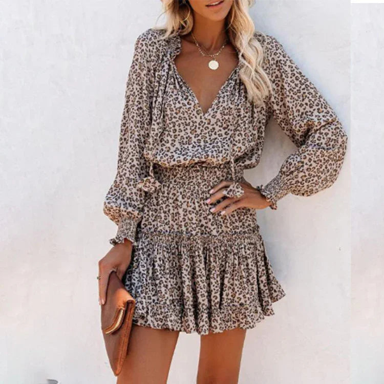 Woman wearing a leopard print long sleeve mini dress with a ruffled hem and relaxed fit