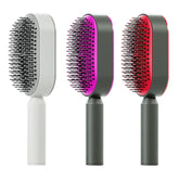 Three modern paddle hairbrushes in white, pink, and red with ergonomic handles